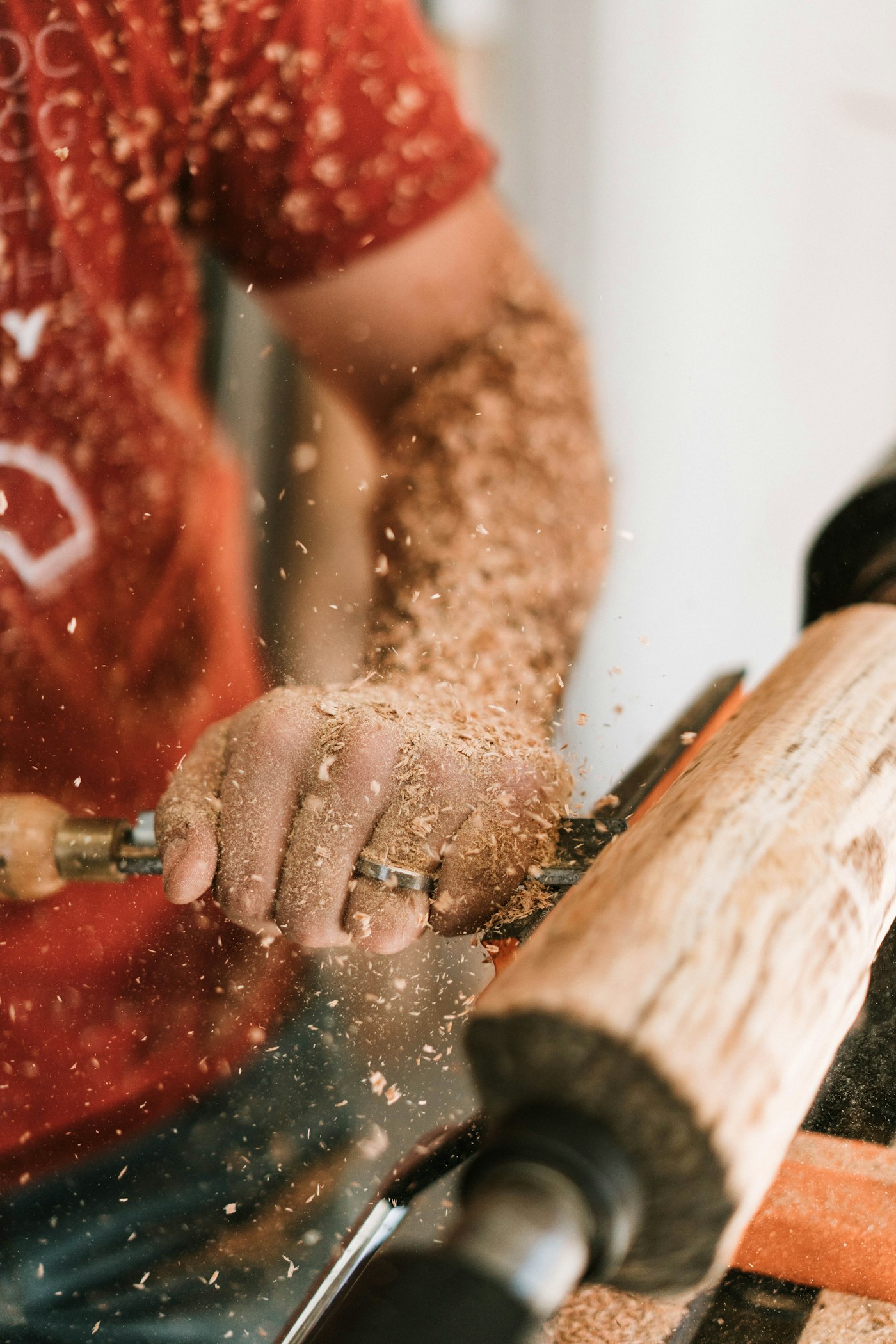 Hands working a board, shavings lifting