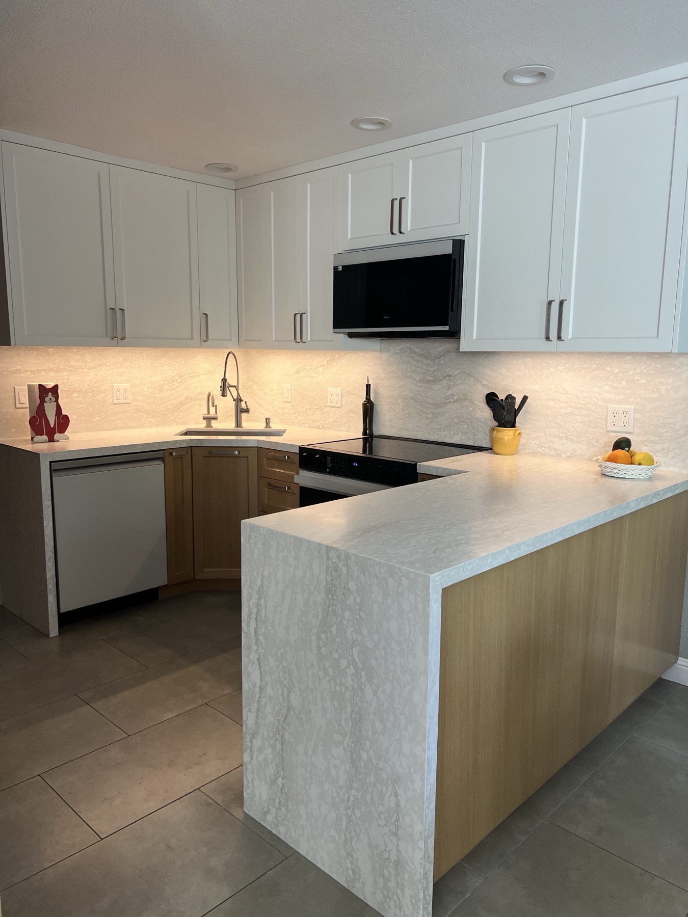 Peninsula with a stone waterfall end and warm-wood cabinet side