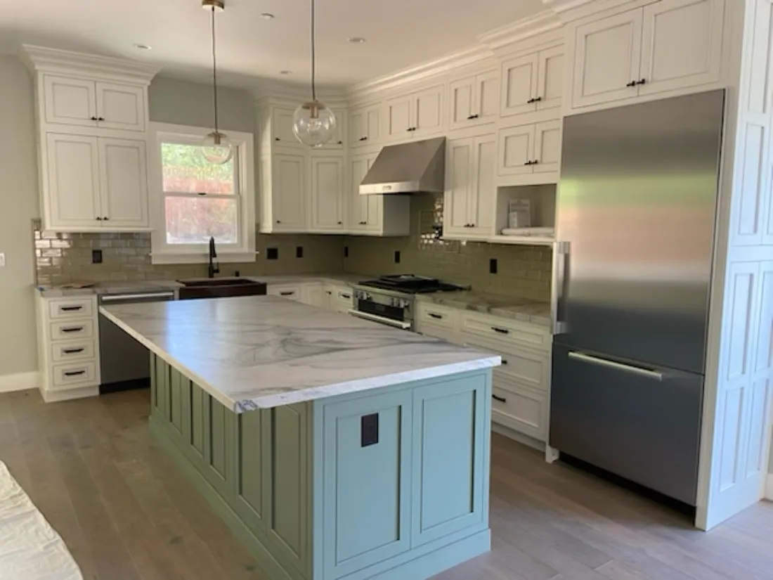 Completed white kitchen with a sage green island